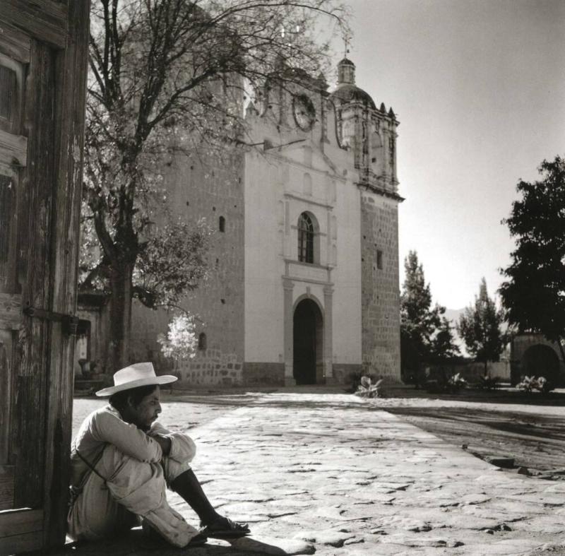 HOMBRE SENTADO EN EL ATRIO DE UNA IGLESIA