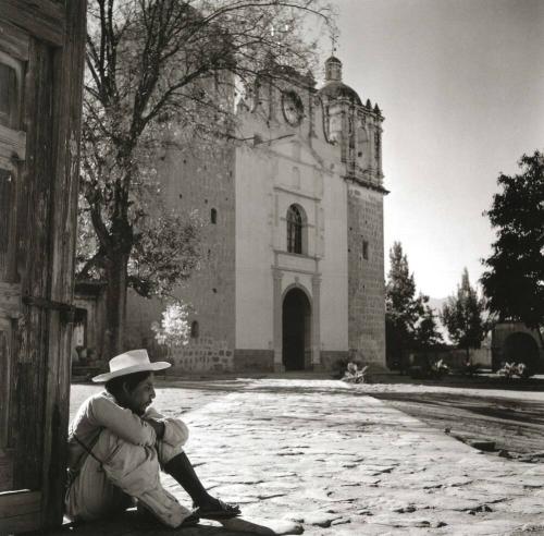 HOMBRE SENTADO EN EL ATRIO DE UNA IGLESIA